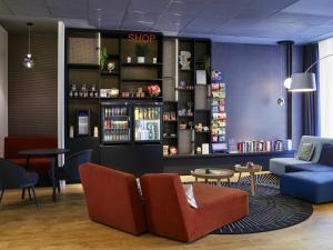 Un vestíbulo con una tienda con sillas y mesas. en Aparthotel Adagio Access La Défense Puteaux, en Puteaux