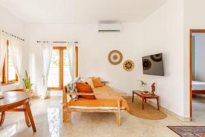 una sala de estar con una cama y una mesa en Villa Ulu 2 bedroom, en Uluwatu