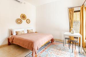 Un dormitorio con una cama y una mesa y una ventana. en Villa Ulu 2 bedroom, en Uluwatu 31 fotos más