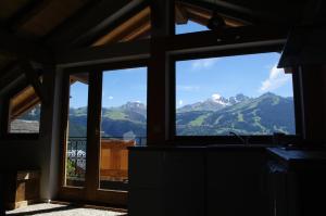 a kitchen with a view of mountains through a window at Petit Chalet Vieux Bois in Bozel