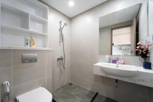 une salle de bains avec lavabo, toilettes et miroir dans l'établissement Selena, à Long Bình