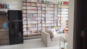 une bibliothèque avec un canapé et une étagère remplie de livres dans l'établissement Selena, à Long Bình