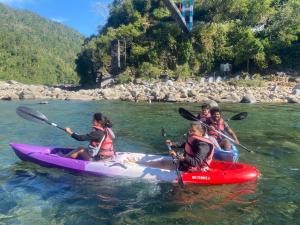 a group of children are kayaking on a river at shnongpdeng tents stay in Dawki +4 photos