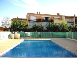 a swimming pool in front of a building at Apartment Les Estivales in Cap d'Agde