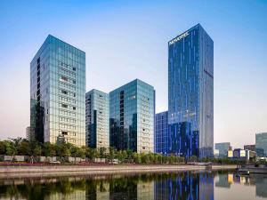 un grupo de edificios altos de cristal en una ciudad en Novotel Ningbo East, en Ningbo