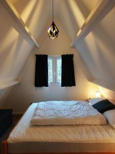 a bedroom with a large bed with a window at Chalets Het Hulstje 1 & 2 - Durbuy in Durbuy