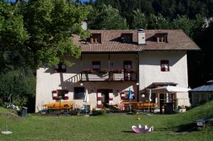 Cette grande maison dispose d'un balcon, de tables et de chaises. dans l'établissement Hotel Zur Kirche, à Magrè allʼ Adige