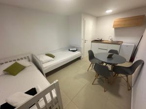 a small room with a bed and a table and chairs at The Sands LUXE Pool Aparthotel, Studio in Novalja