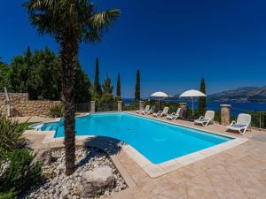una piscina en una villa con palmeras en Villa Alegria Cavtat - Studio Apartment with Patio and Garden View, en Cavtat