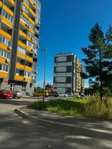 a tall building on a street with a parking lot at Start Life in Vyshhorod