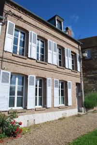 an old brick building with white windows and shutters at Maisonnette à Saint Valéry Sur Somme in Saint-Valéry-sur-Somme
