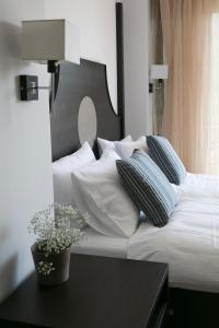 パルガにあるLina's Apartmentsの白いベッド(枕付)、植物テーブル