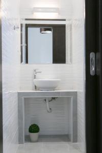 W łazience znajduje się umywalka i lustro. w obiekcie Lina's Apartments w mieście Parga