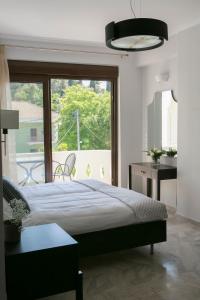 sypialnia z łóżkiem i dużym oknem w obiekcie Lina's Apartments w mieście Parga