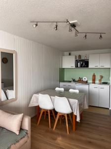 a kitchen and dining room with a table and chairs at Le nid du Buron - Super-Besse in Besse-et-Saint-Anastaise