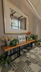 a mirror on a wall above a table with plants at Apart Anderson in Surabaya
