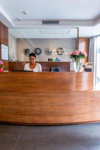 a woman standing at the reception desk of a practition at Art Hotel Eiffel in Paris