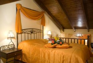 a bedroom with a bed with an orange bedspread at Celena Maisonettes in Arachova