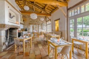 PuylaurensにあるCap de Castelのテーブルと椅子、暖炉のあるレストラン