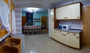 a kitchen with a sink and a microwave at CASA LA FÀBRICA in Horta de San Joan
