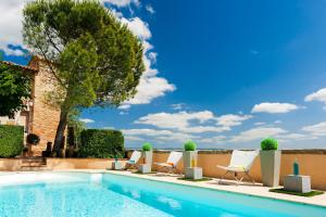 a swimming pool with lounge chairs and a tree at Cap de Castel in Puylaurens