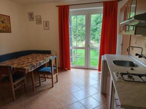 a kitchen with a table and a kitchen with red curtains at Apartman Janky 299 in Trutnov