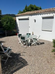 un patio avec une table et des chaises devant un bâtiment dans l'établissement Cottage a Vidauban, à Vidauban