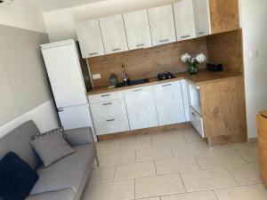 une cuisine avec des armoires blanches et un canapé dans une pièce dans l'établissement Cottage a Vidauban, à Vidauban