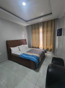 une chambre avec un lit, une chaise et une fenêtre dans l'établissement Kigali Mechatronics Place, à Kigali