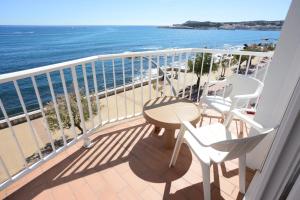 a balcony with a table and chairs and the ocean at Rallye Hotel in L'Escala