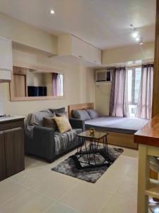 - un petit salon avec un canapé et un lit dans l'établissement Modern Condo,Pool, Avida Riala Tower1, à Cebu