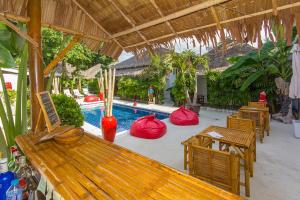 a pool with tables and chairs and a wooden bench at The White Cottage in Bophut