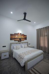 a bedroom with a bed and a ceiling fan at Hotel Magdalina Lagoon in Negombo