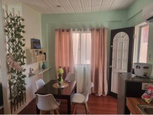 にあるAZ's Place, comfy and homey vibesのテーブルと白い椅子のあるダイニングルーム