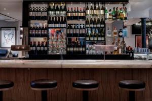 un bar con taburetes negros y botellas de vino en Old Bank Hotel, en Oxford