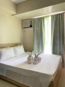 deux lapins assis sur un lit dans une chambre dans l'établissement Modern Condo,Pool, Avida Riala Tower1, à Cebu
