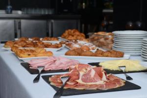 a table topped with plates of meats and pastries at Rallye Hotel in L'Escala