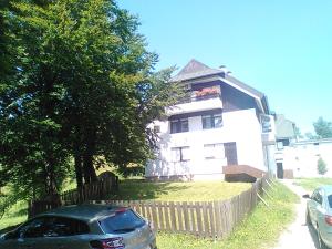 a house with a car parked in front of it at Art Apartman in Plitvička Jezera +3 photos
