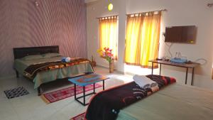a bedroom with a bed and a tv in it at Nilachal Homes in Guwahati