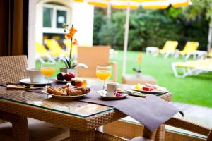 a table with plates of food and glasses of orange juice at La Closerie SPA & Résidence Hôtel in Deauville
