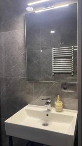 a bathroom with a white sink and a mirror at Світлий номер для трьох осіб N9 in Chernivtsi