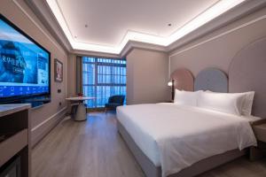 una habitación de hotel con cama y televisor de pantalla plana en Mercure Hefei South Railway Station, en Hefei