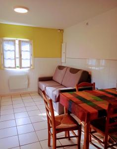 a living room with a couch and a table at Maisonnette "Les Volets Bleus" in Orgedeuil +11 photos