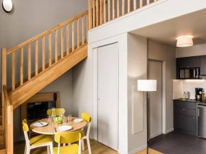 a dining room with a table and yellow chairs at Aparthotel Adagio access Colombes La Défense in Colombes