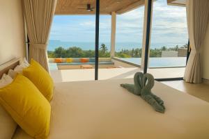 Un dormitorio con una cama con una ventana grande. en Villa Sabanya Sea View, en Ban Nua
