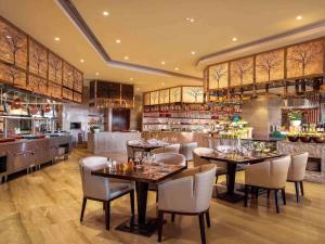 a restaurant with tables and chairs and a bar at Sofitel Lianyungang Suning in Lianyungang