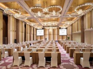 a large room with tables and chairs and chandeliers at Sofitel Lianyungang Suning in Lianyungang +82 photos