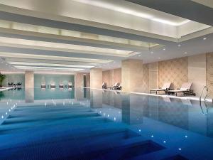 a large swimming pool in a hotel lobby at Sofitel Lianyungang Suning in Lianyungang