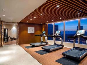 a gym with elliptical machines and a large window at Sofitel Lianyungang Suning in Lianyungang