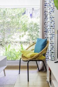 a wicker chair with a blue pillow sitting in front of a window at T2 Port de Vannes in Vannes